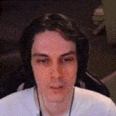 a man wearing headphones is sitting in front of a computer screen .
