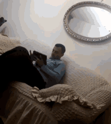 a man sits on a couch reading a book