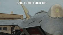 a picture of a fighter jet with the words shut the fuck up below it