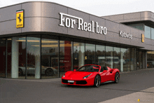 a red car is parked in front of a for real bro building