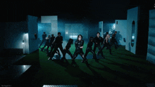 a woman in a black jacket is dancing with a group of dancers