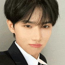 a young man in a suit and tie is making a face .