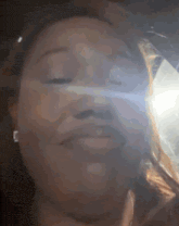 a close up of a woman 's face with a light shining on it