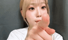 a woman is making a heart shape with her fingers .