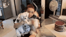 a woman is sitting at a table holding a dog .