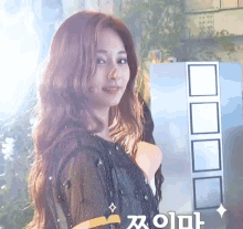 a woman in a black dress is standing in front of a sign that says ' korean ' on it .