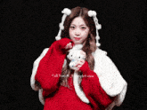 a girl in a red sweater holds a hello kitty stuffed animal