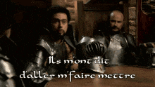 two men in armor are sitting at a table with the words " ils mon dit d'aller m'faire mettre "