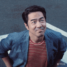 a man wearing a striped shirt and a denim jacket with netflix on the bottom