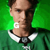 a man wearing a green nhl jersey with the letter g behind him