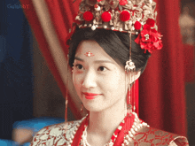 a woman wearing a red and gold costume and a crown with the word gulubby on the bottom