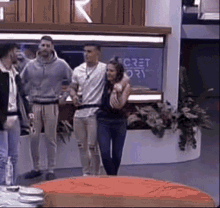 a group of people are standing in front of a sign that says secret diary
