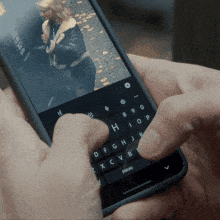 a person is typing on a phone with a picture of a woman