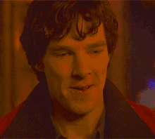 a close up of a man 's face with a red jacket on