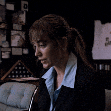a woman in a suit is sitting in front of a flag