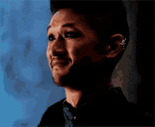 a man with a piercing in his ear is smiling .