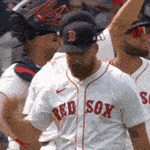 a man wearing a red sox jersey stands in a line