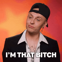 a man wearing a baseball cap and a suit says i 'm that bitch