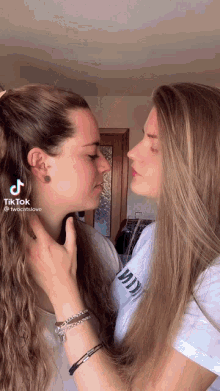 a tiktok video of two women kissing with the words twocatslove at the bottom