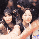a woman taking a selfie with another woman with a camera