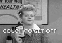 a woman is holding a bottle of cough medicine in her hand .