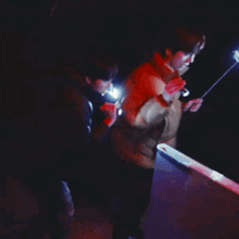two people are looking at something with a flashlight