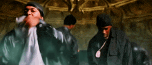 a group of men are standing in a dark room with smoke coming out of the ceiling
