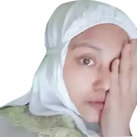 a woman wearing a hijab covering her face with her hands