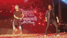 a man and a woman are dancing on stage in front of a sign that says ' rita ' on it