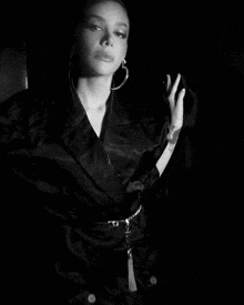 a black and white photo of a woman with a tattoo on her wrist