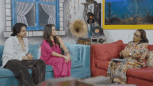 a man and two women are sitting on a couch