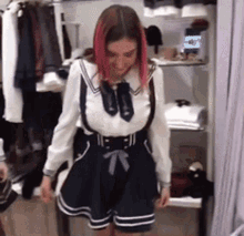 a woman with pink hair is standing in a closet