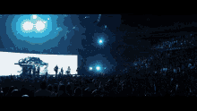 a crowd of people with their hands in the air at a concert