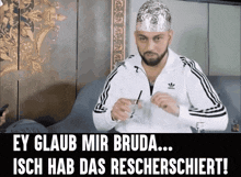 a man wearing a tin foil hat and a adidas jacket