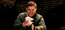 a man is holding a hammer in his hands and making a face .