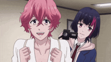 a girl with pink hair is taking a picture of another girl with black hair