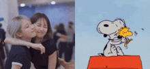 two girls hugging next to a picture of snoopy