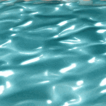 a close up of a blue water surface with waves and reflections