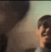 a close up of a person 's face in a blurry photo with a blurred background .