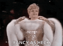 a woman in a fur coat is standing on a stage and says `` fancy as heck '' .