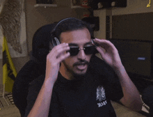 a man wearing sunglasses and headphones has a shirt that says navy