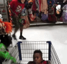 a baby in a shopping cart is being pushed by a man