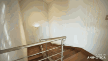 a wooden staircase with a metal railing and the words made in animotica on the bottom