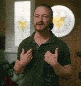 a man in a green shirt is giving a thumbs up