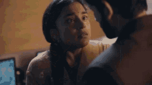a man and a woman are kissing in a room . the woman is wearing a yellow blouse .