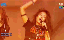 a woman is singing into a microphone while wearing a shirt that says acdc