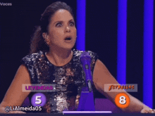 a woman sitting in front of a microphone with the number 5 and 8 on her shoulder