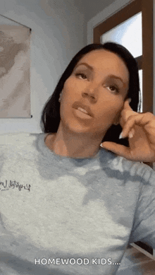 a woman is talking on a cell phone while wearing a blue shirt .