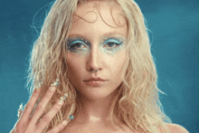 a woman with a nose ring has a blue eye makeup