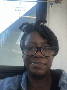 a woman wearing glasses and a headband smiles for a photo